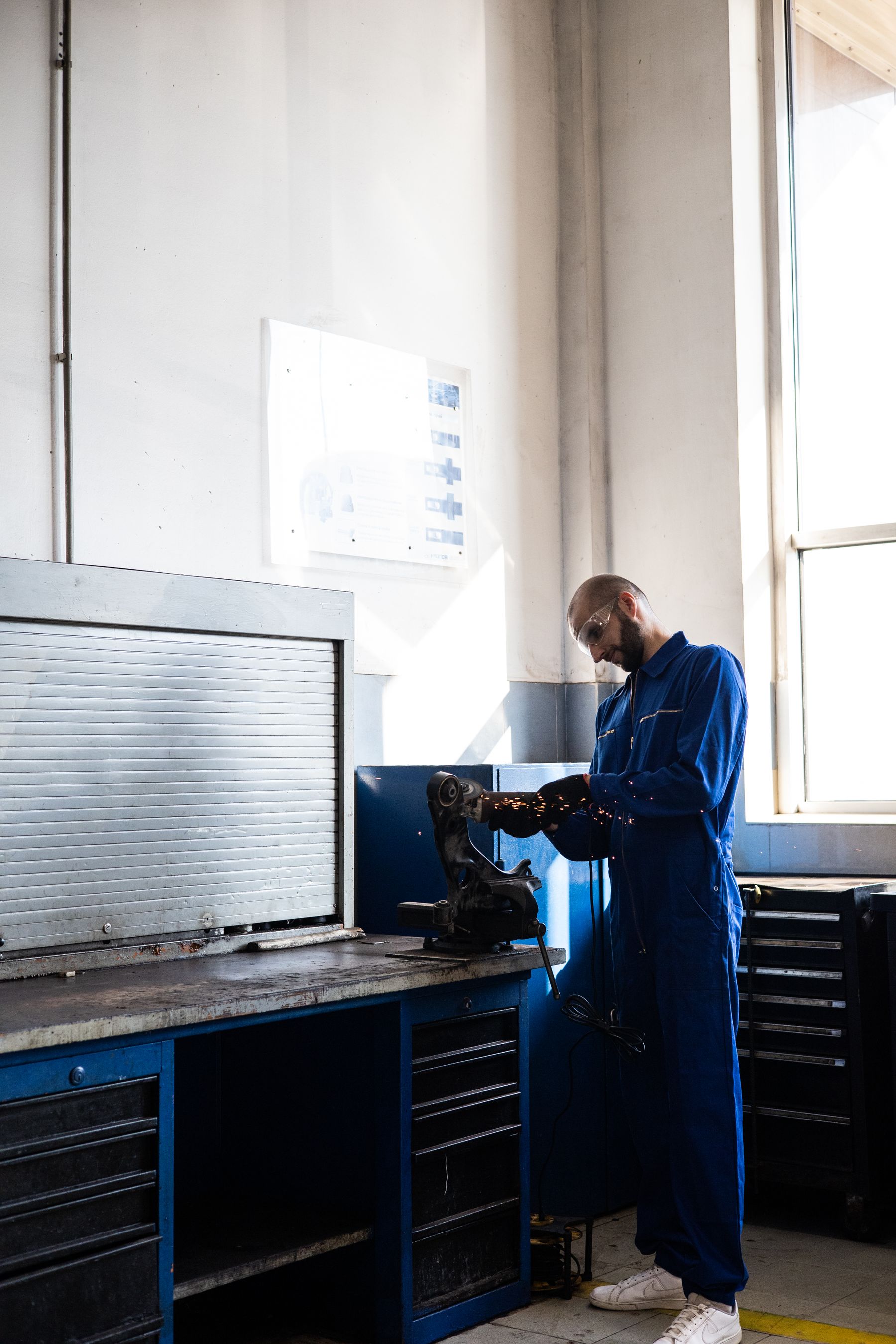 Mechanic working at a bench in a bright auto workshop